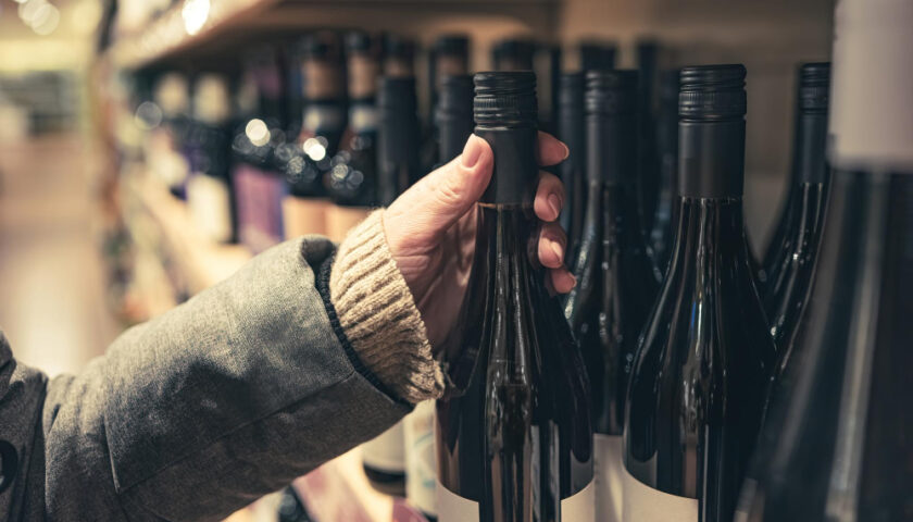 une personne prenant une bouteille de vin dans ses mains